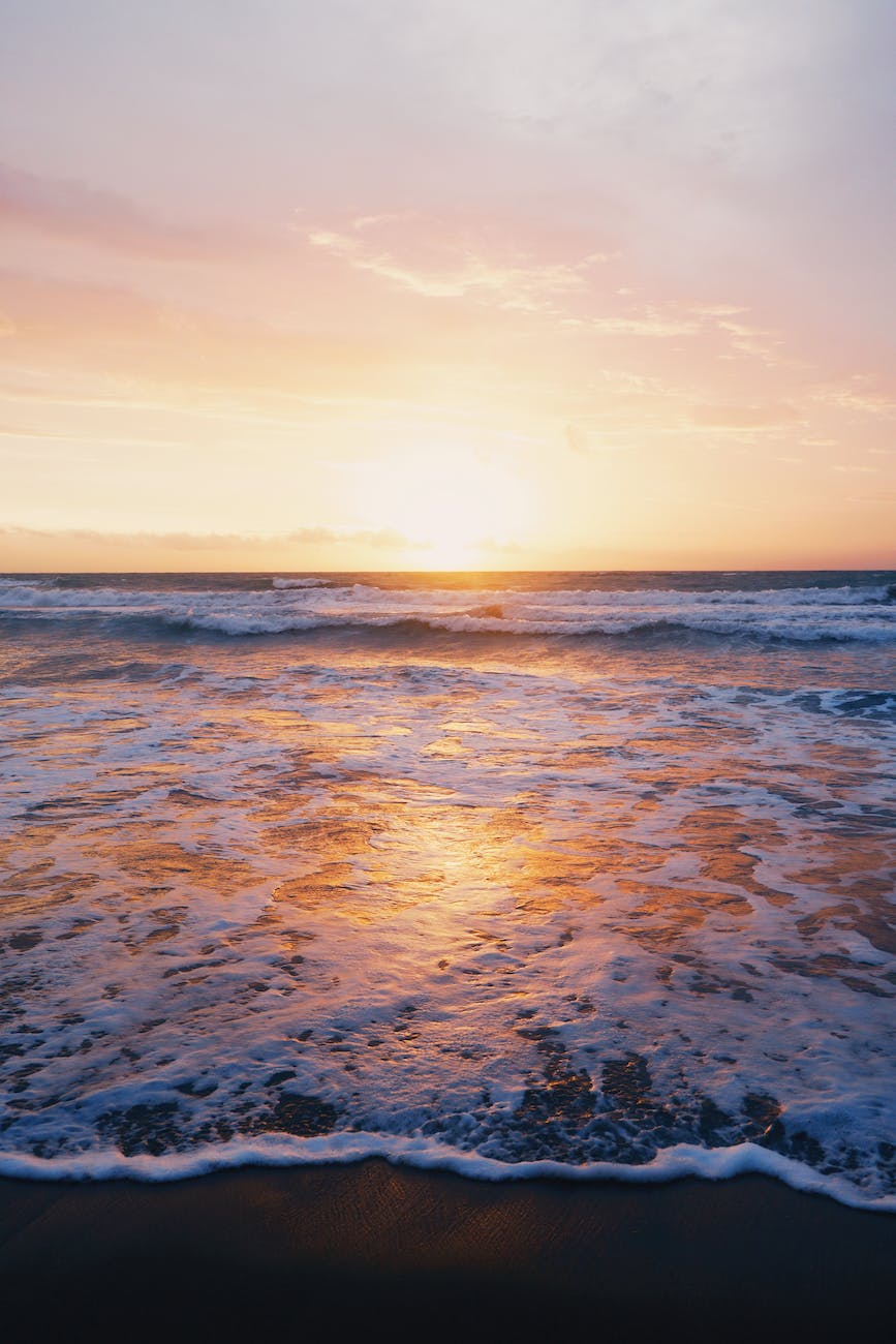 photo of ocean waves near seashore during sunset